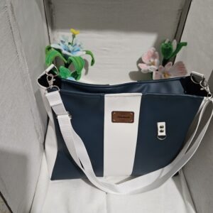 Se sac à bandoulière est en simili cuir bleu vert et blanc , se ferme avec une fermeture éclair et une anse réglable .