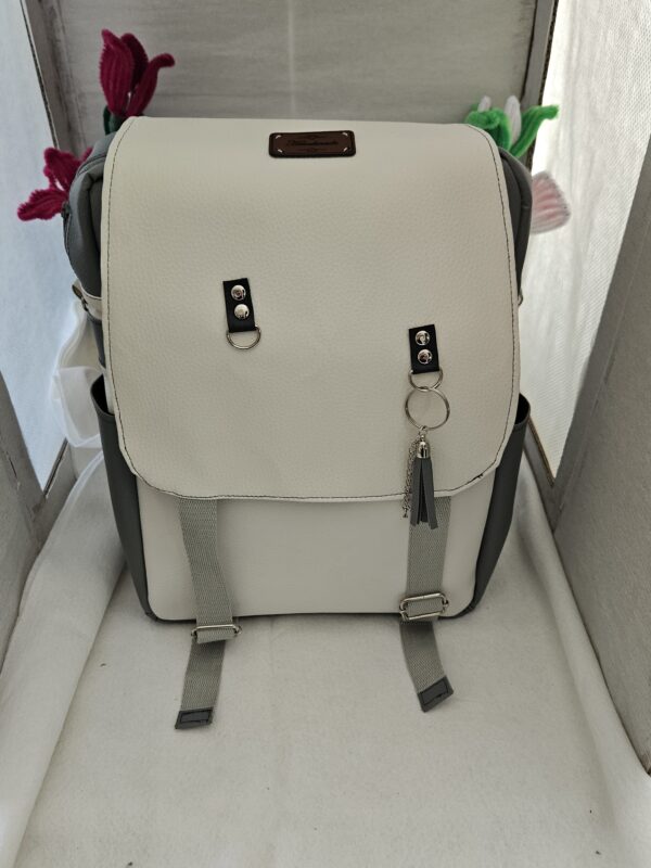 Sac à dos gris et blanc en simili cuir.